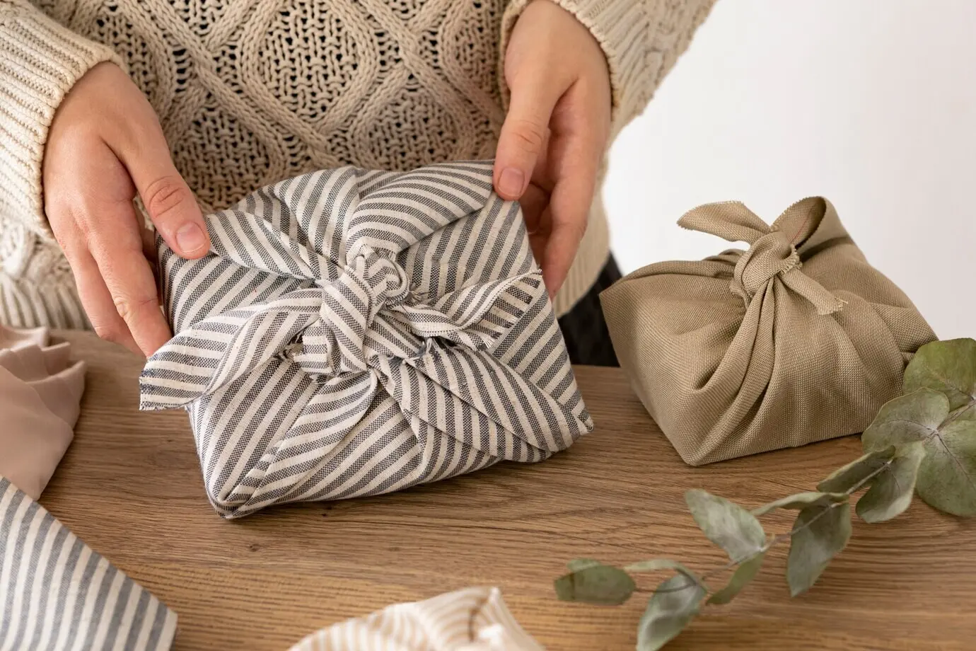 Eine Person packt ein Weihnachtsgeschenk ein.